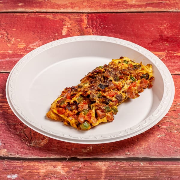 A Railroad Cafe omelet with ham, peppers, and tomatoes on a white plate.